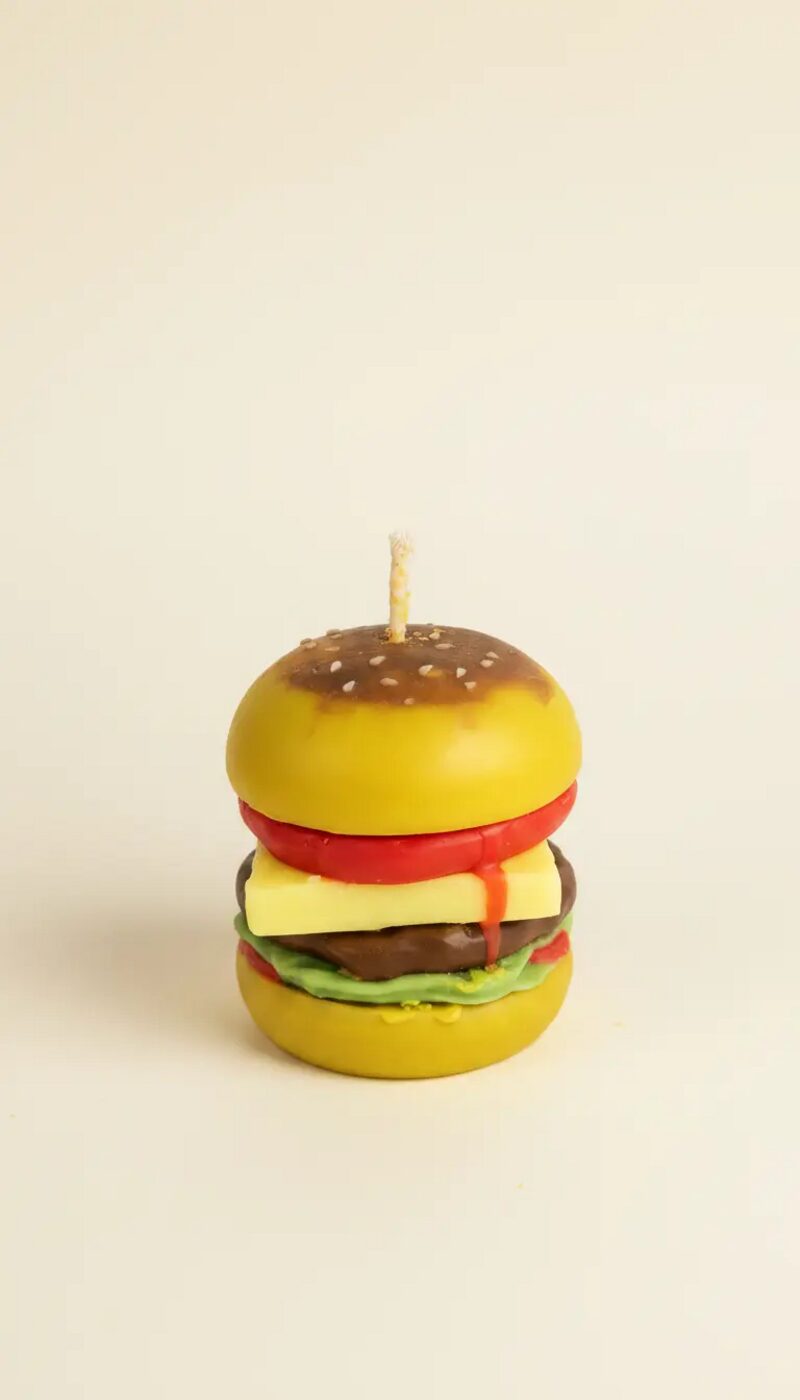 Hamburger alakú, sárga buci, piros paradicsom, sárga sajt, barna húspogácsa és zöld saláta rétegekkel, pamut kanóccal.