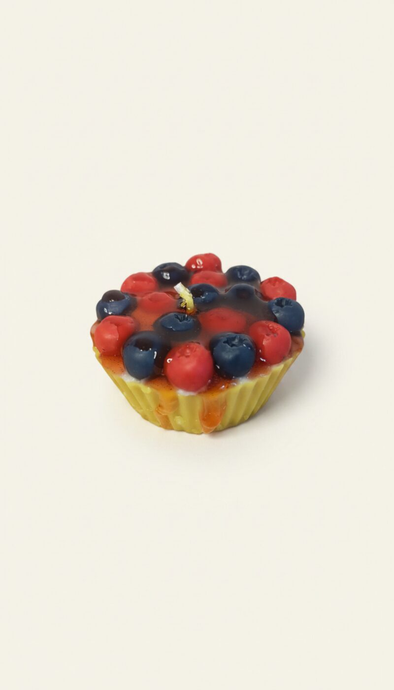 Áfonyás muffin alakú dekorgyertya, aranybarna sütemény formával és áfonyaszemekkel.