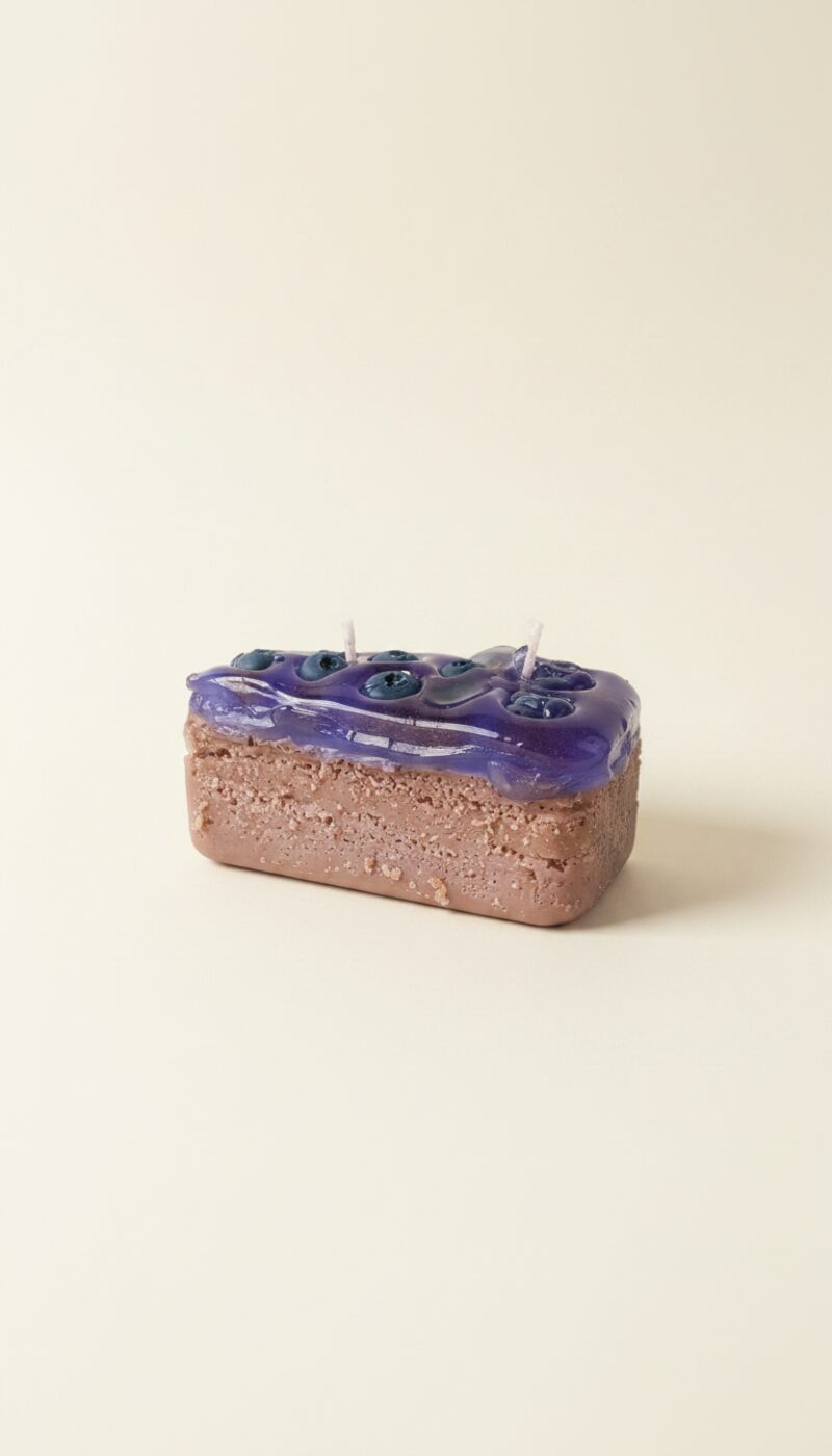Réteges áfonyás tortaszelet szójaviasz gyertya, sötétlila áfonyabevonattal és piskótaalappal.