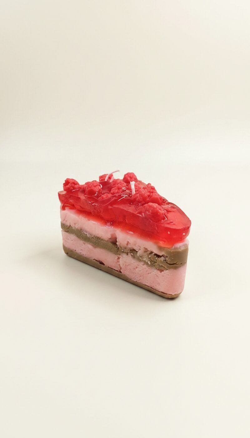 Málnás tortaszelet alakú szójaviasz gyertya, piros zselével és málnaszemekkel.