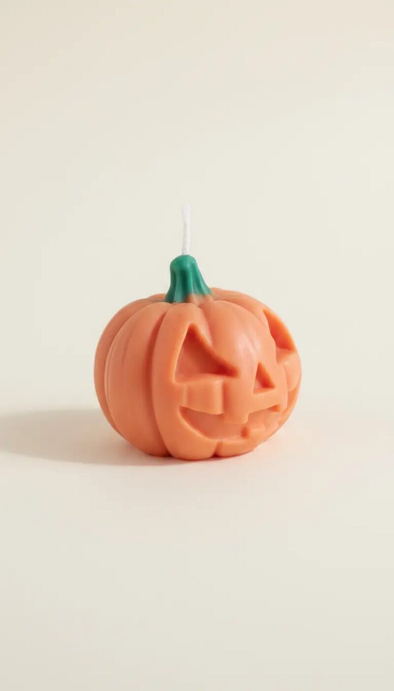 Halloweeni tök gyertya háromszög szemekkel, oldalnézetből, bordázott tökformával.