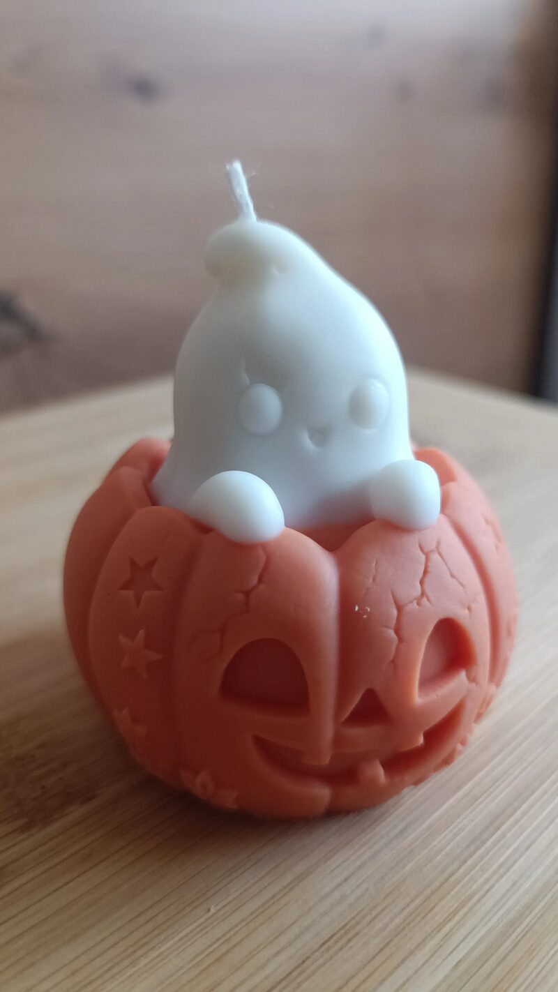Halloween tök gyertya kis szellemmel, közeli nézetből a mintás tökhéjjal.