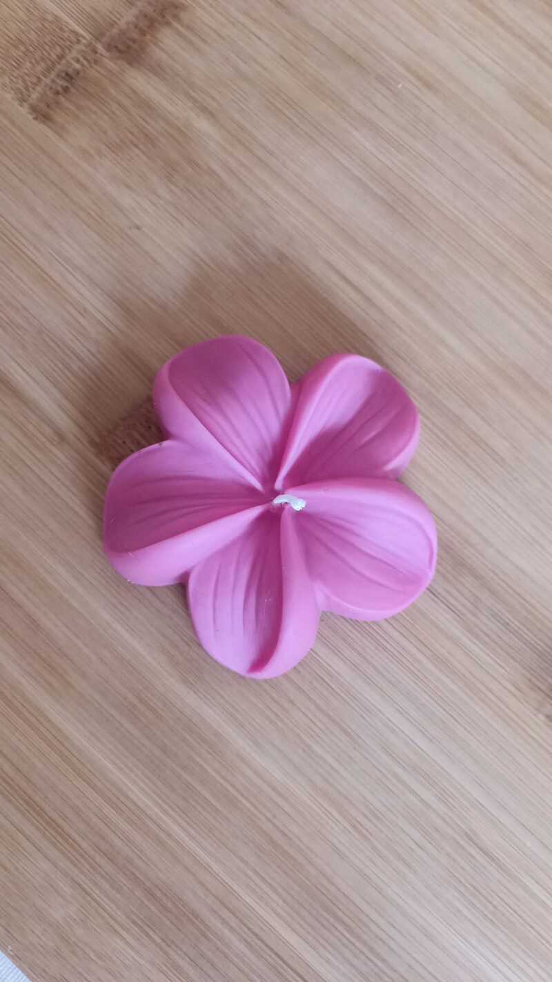 Ciklámen színű plumeria virág alakú szójaviasz gyertya felülnézetből, öt erezett szirommal.